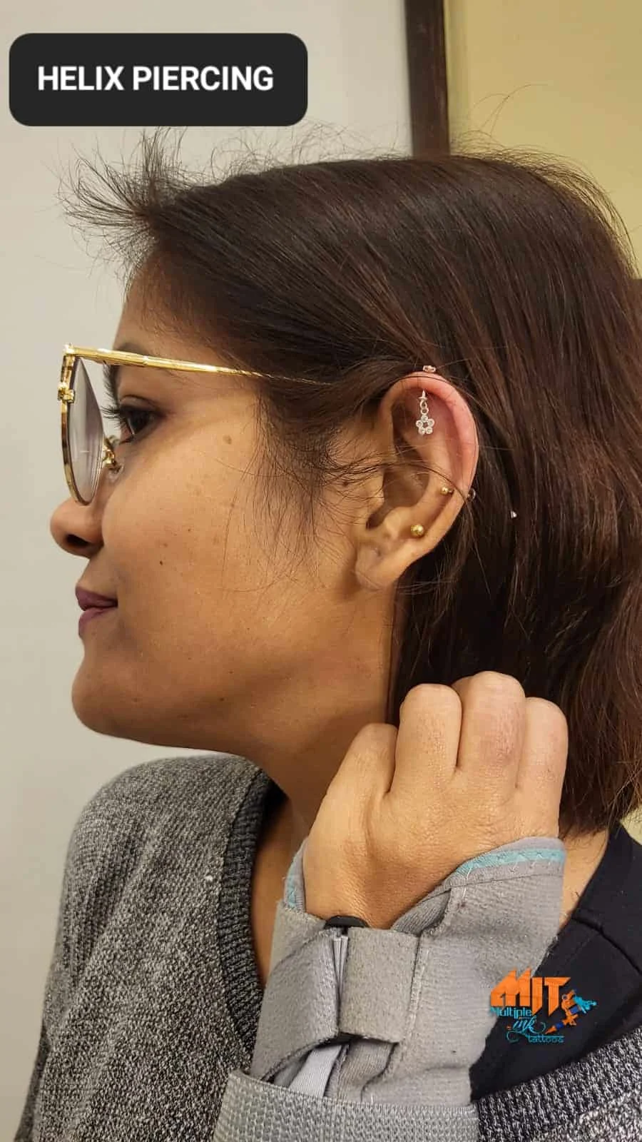 Woman wearing decorative jewellery after helix piercing in Palam, Delhi